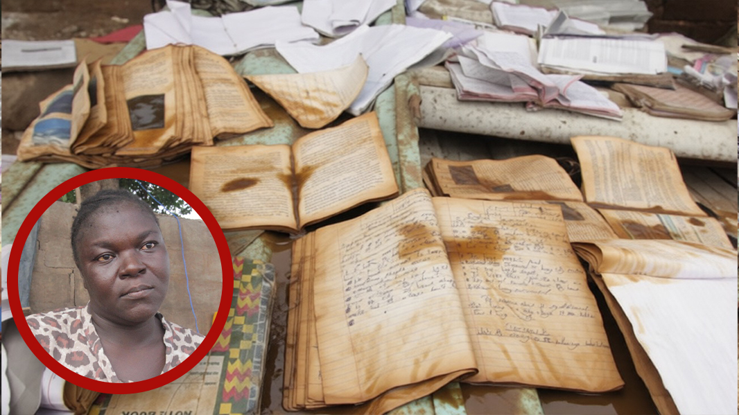 Georgina Adjowoda sits beside waterlogged schoolbooks spread across rusted metal sheets under the afternoon sun